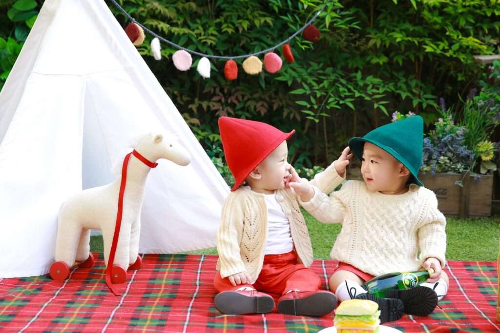 Two class of children sitting outside in park